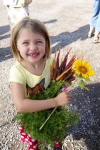 A sweet smile with sunflower and purple carrots.