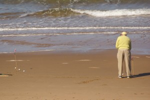 Man playing golf on beach in Inverness.