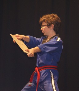 Tom holds a piece of wood, soon to be broken.